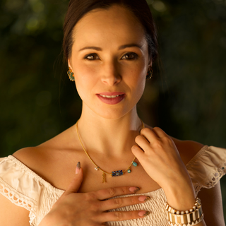 Woman wearing a necklace with a dark background