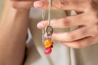 hands showing chams on necklaces