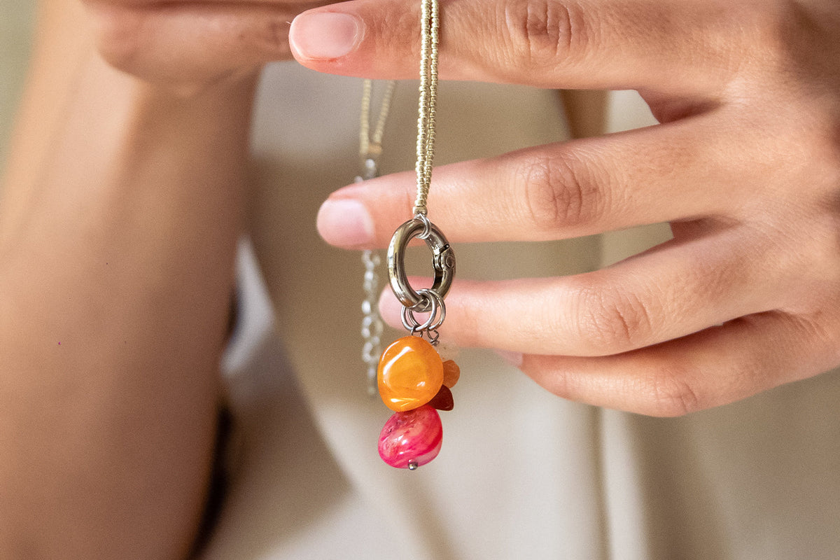 hands showing chams on necklaces