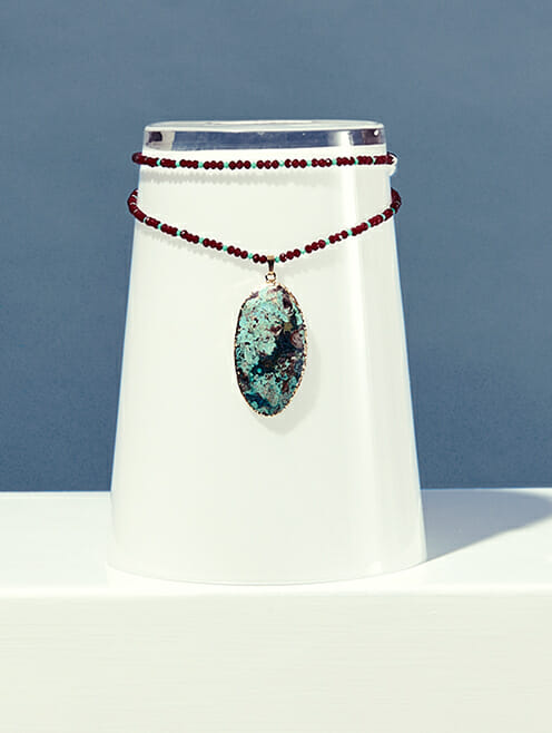 turquoise stone on maroon and blue crystal beads lifestyle