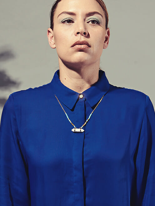 point pendant with turquoise beads on gold chain blue shirt