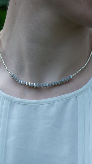 Soft grey faceted beads rest gracefully along the neckline, giving this ladies' necklace an elegant finish that complements both casual and occasion wear.
