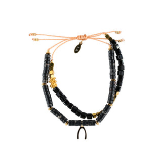 Handcrafted layered bracelet featuring black faceted and disc beads, gold-tone accents and an adjustable cord fastening, finished with a distinctive wishbone charm.