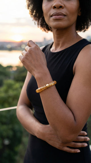 A woman wearing a sparkling gold resin bracelet that adds a radiant finishing touch to an elegant evening outfit, effortlessly blending glamour with modern sophistication.