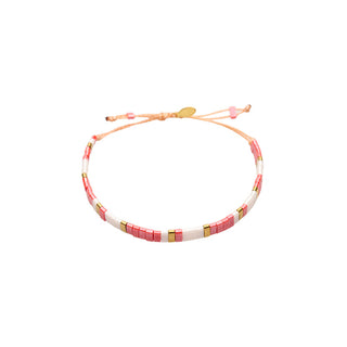 Adjustable bracelet crafted with soft pink and white Miyuki tile beads, accented by polished gold spacers and a sliding cord closure for a delicate, feminine finish.