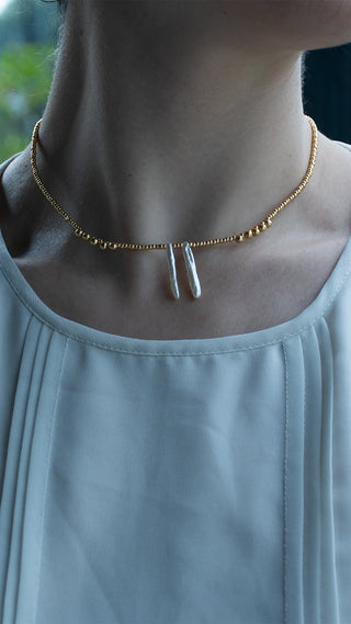 Gracefully resting along the neckline, this women's gold necklace pairs luminous freshwater pearls with delicate gold beads for understated everyday elegance.