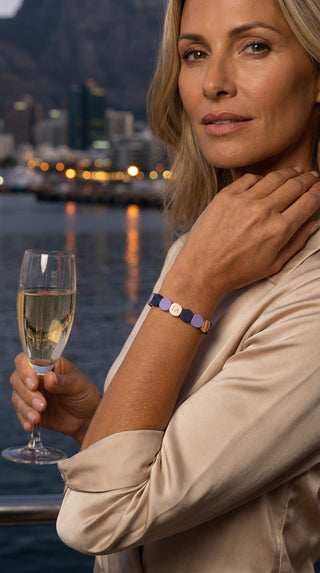 A woman enjoying a sunset gathering while wearing the Tribal Mosaic Bracelet with geometric colour-blocked detailing.